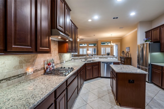 kitchen with sink, appliances with stainless steel finishes, hanging light fixtures, a center island, and kitchen peninsula