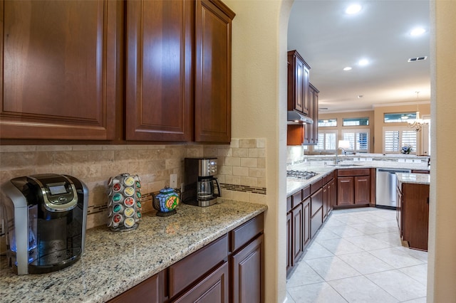 kitchen featuring sink, hanging light fixtures, ornamental molding, stainless steel appliances, and backsplash