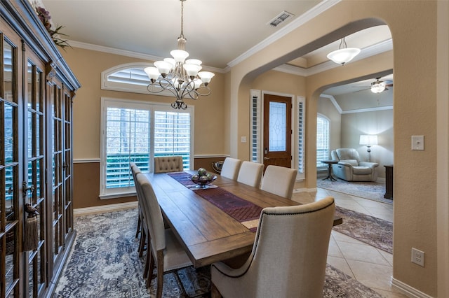 tiled dining room with ornamental molding and ceiling fan with notable chandelier