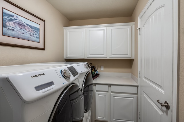 clothes washing area featuring independent washer and dryer and cabinets