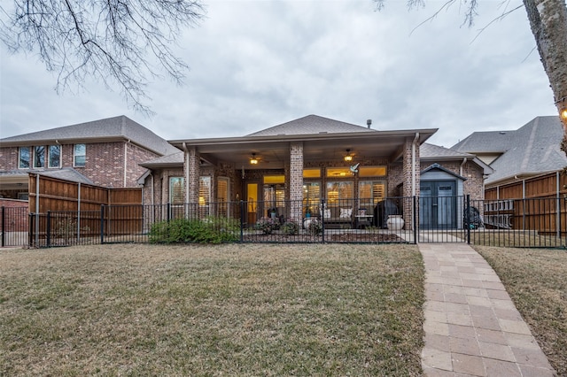 rear view of house featuring ceiling fan, a yard, and a patio