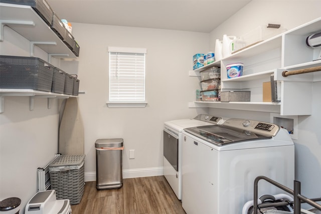 laundry room featuring washing machine and clothes dryer and wood-type flooring