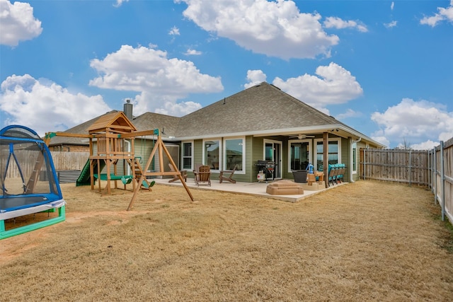 exterior space featuring a trampoline, a patio area, and a lawn