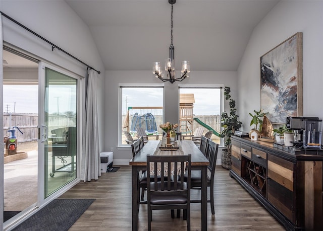 dining area with vaulted ceiling, dark wood-type flooring, and a notable chandelier