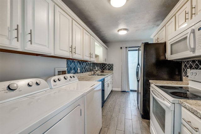 clothes washing area featuring separate washer and dryer and sink