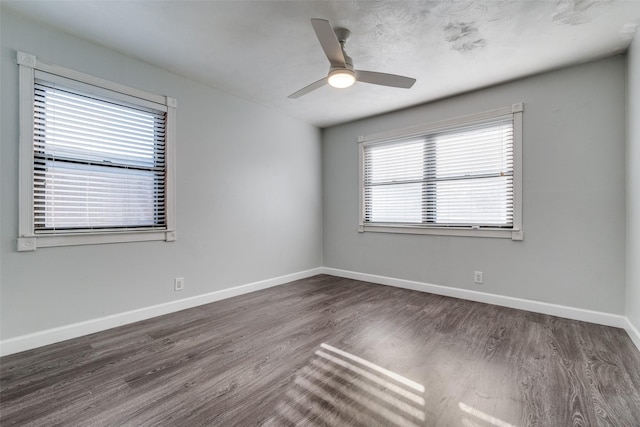 empty room with dark wood-type flooring, ceiling fan, and plenty of natural light