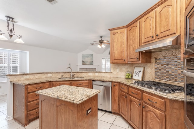 kitchen featuring appliances with stainless steel finishes, pendant lighting, tasteful backsplash, sink, and kitchen peninsula