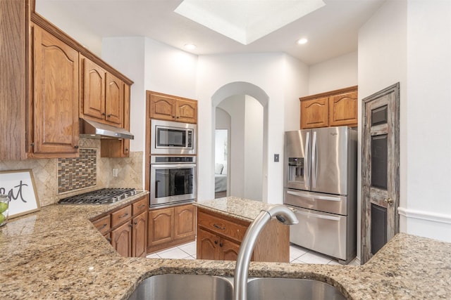 kitchen with tasteful backsplash, sink, light tile patterned floors, and stainless steel appliances