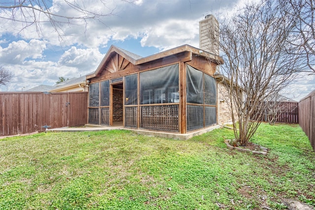 back of property with a sunroom and a yard