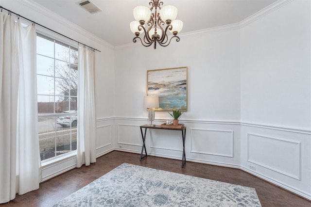 interior space featuring crown molding, an inviting chandelier, and dark wood-type flooring