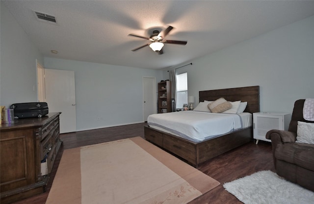 bedroom featuring dark hardwood / wood-style flooring, a textured ceiling, and ceiling fan