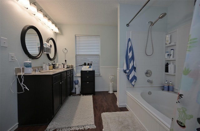 bathroom with vanity, hardwood / wood-style flooring, a textured ceiling, and shower / bath combo