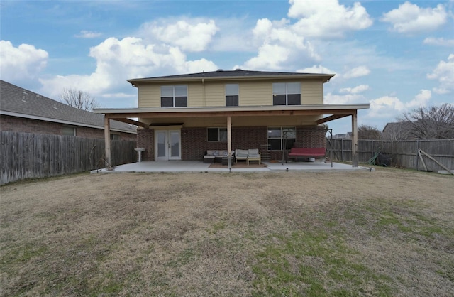 back of property with a patio, outdoor lounge area, a yard, and french doors