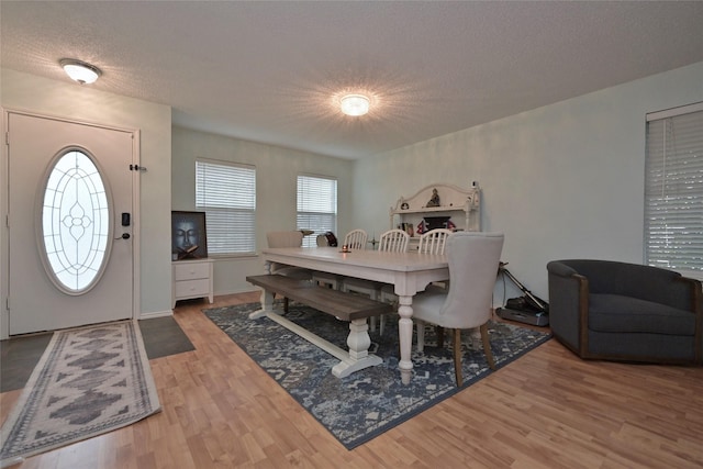 dining space featuring hardwood / wood-style floors and a textured ceiling