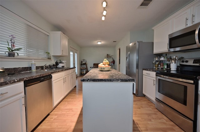 kitchen featuring stainless steel appliances, white cabinetry, a center island, and light wood-type flooring