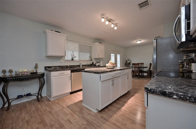 kitchen featuring stainless steel appliances, white cabinetry, a textured ceiling, and light hardwood / wood-style floors