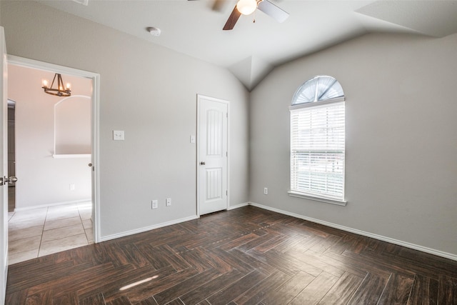 spare room with lofted ceiling, dark parquet flooring, and ceiling fan