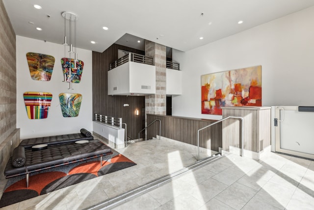 interior space featuring a high ceiling, white cabinetry, and light tile patterned flooring