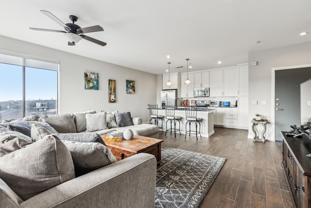 living room with dark wood-type flooring and ceiling fan