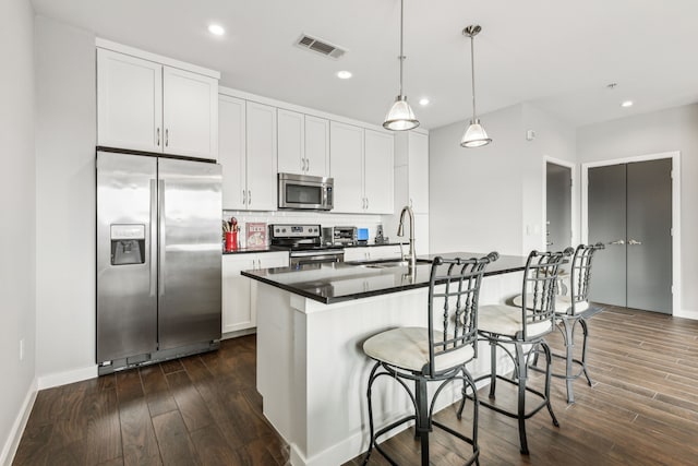 kitchen featuring sink, hanging light fixtures, white cabinets, and appliances with stainless steel finishes