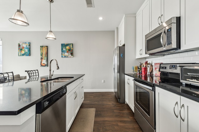 kitchen with white cabinetry, appliances with stainless steel finishes, sink, and hanging light fixtures