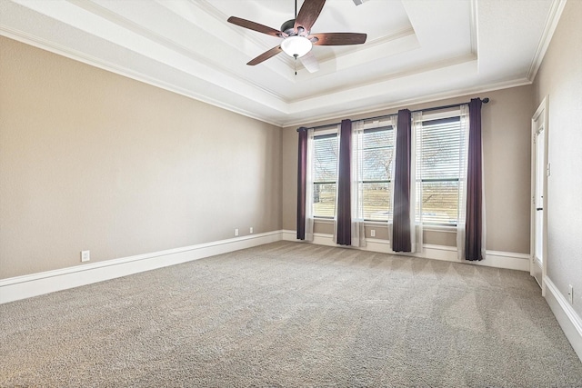 carpeted spare room featuring ornamental molding, a healthy amount of sunlight, ceiling fan, and a tray ceiling