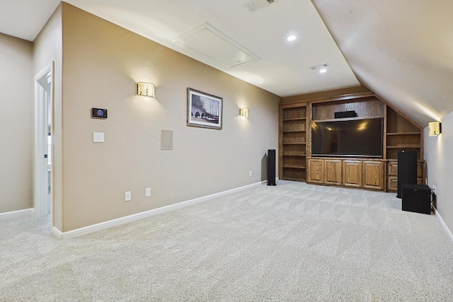 unfurnished living room featuring built in shelves, vaulted ceiling, and light colored carpet