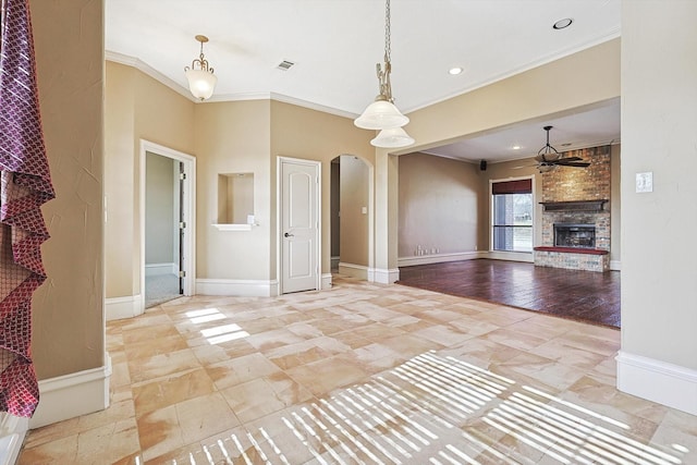 unfurnished living room with crown molding, a brick fireplace, and ceiling fan