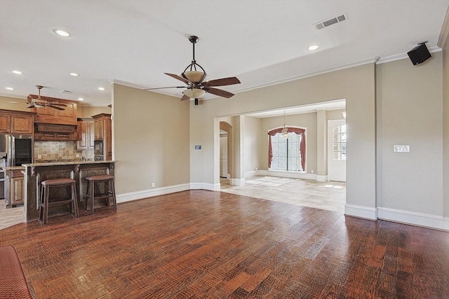 unfurnished living room featuring crown molding, ceiling fan, and hardwood / wood-style flooring