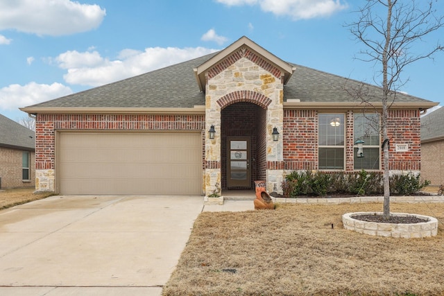 french country home featuring a garage, brick siding, driveway, stone siding, and roof with shingles