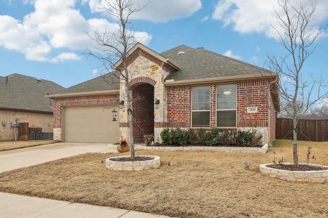 view of front of home featuring brick siding, a shingled roof, fence, stone siding, and driveway