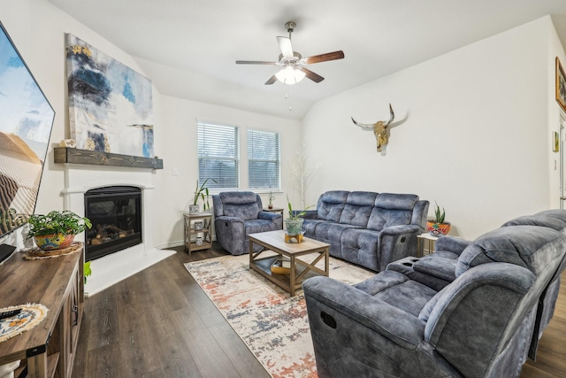 living room with ceiling fan, dark hardwood / wood-style floors, and vaulted ceiling