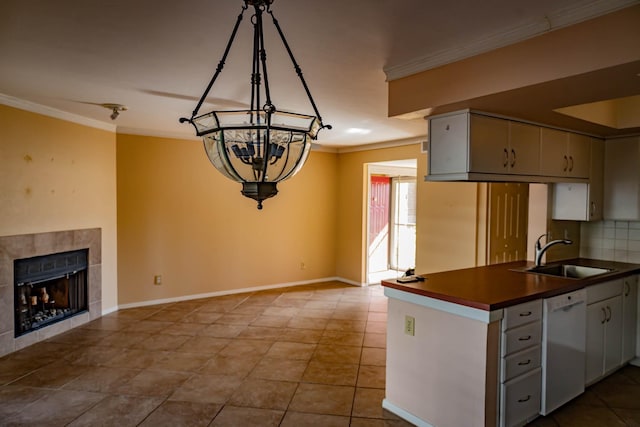 kitchen featuring a fireplace, white cabinetry, dishwasher, sink, and ornamental molding