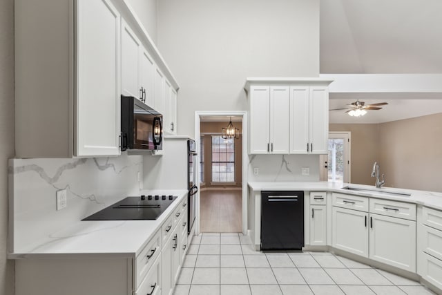 kitchen featuring tasteful backsplash, white cabinetry, sink, and black appliances