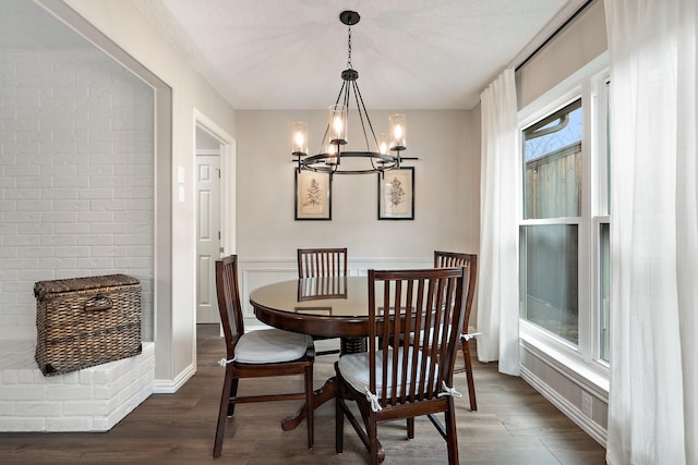 dining space with dark hardwood / wood-style flooring, a chandelier, and a textured ceiling