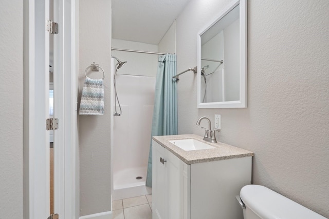 bathroom featuring tile patterned flooring, vanity, a shower with curtain, and toilet