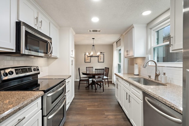 kitchen with appliances with stainless steel finishes, sink, and white cabinets