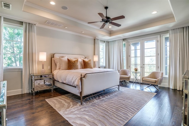 bedroom with a raised ceiling and dark wood-type flooring