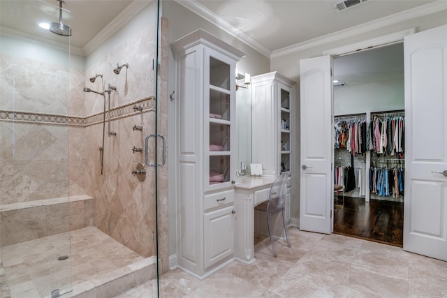 bathroom with ornamental molding and tiled shower