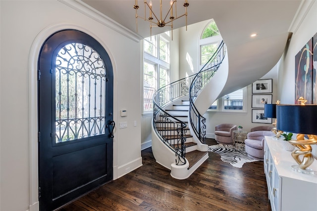 foyer featuring crown molding, a chandelier, and dark hardwood / wood-style flooring