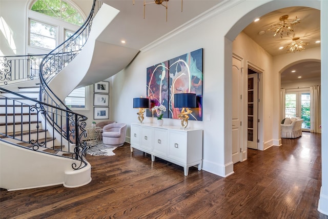 stairway with ornamental molding and hardwood / wood-style floors