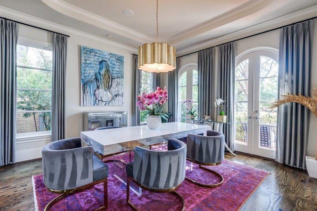 dining space featuring crown molding, french doors, a healthy amount of sunlight, and hardwood / wood-style flooring