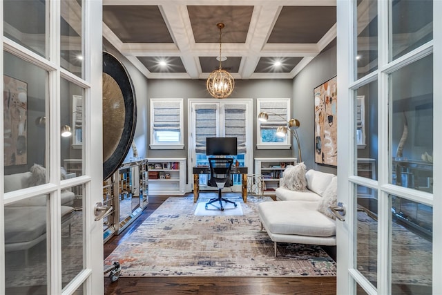 home office with coffered ceiling, ornamental molding, dark hardwood / wood-style floors, a notable chandelier, and beam ceiling