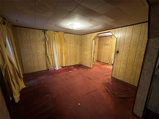 basement with wooden walls and dark colored carpet