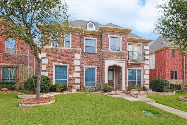 view of front facade featuring a balcony and a front yard