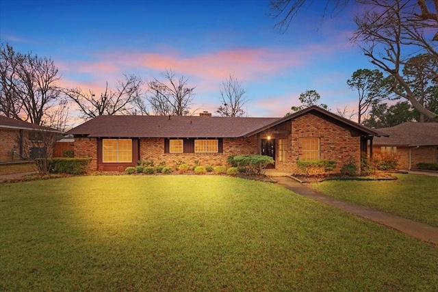 ranch-style home with a lawn