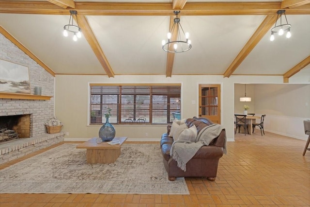 living room with a brick fireplace, vaulted ceiling with beams, and an inviting chandelier