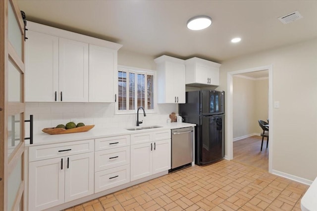 kitchen with black refrigerator, white cabinetry, dishwasher, sink, and decorative backsplash