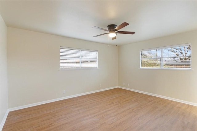 empty room with ceiling fan, a healthy amount of sunlight, and light wood-type flooring