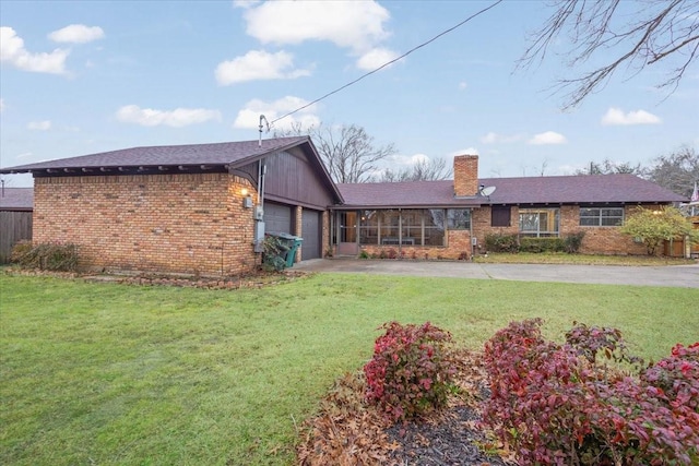 rear view of house featuring a garage and a lawn